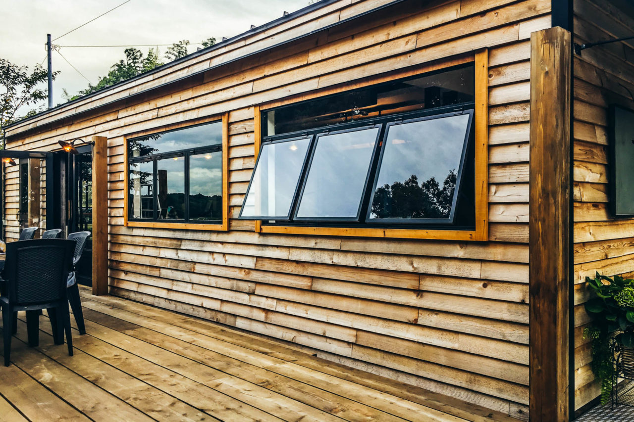 木板貼りの外壁と突き出し窓のあるテラス